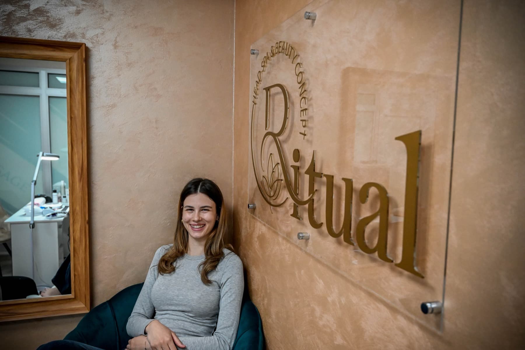 A guest at RITUAL by the gold logo wall